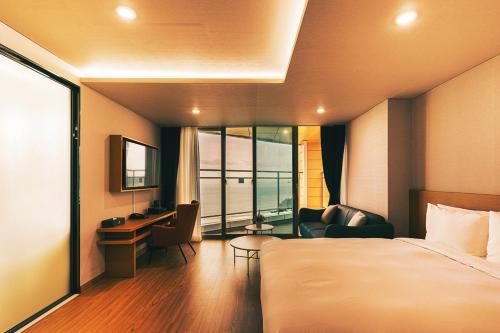 a hotel room with a bed and a desk and chair at Kwangsu Hotel Haeundae in Busan