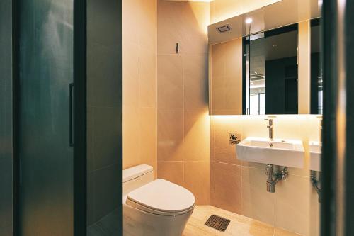 a bathroom with a toilet and a sink and a mirror at Kwangsu Hotel Haeundae in Busan