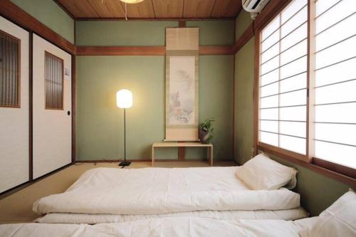 a bedroom with two beds in a room with windows at Osaka MISAKI Traditional Japanese house 2-6 ppl near station in Osaka