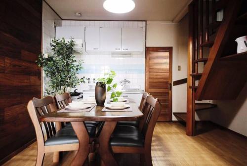 a dining room with a wooden table and chairs at Osaka MISAKI Traditional Japanese house 2-6 ppl near station in Osaka