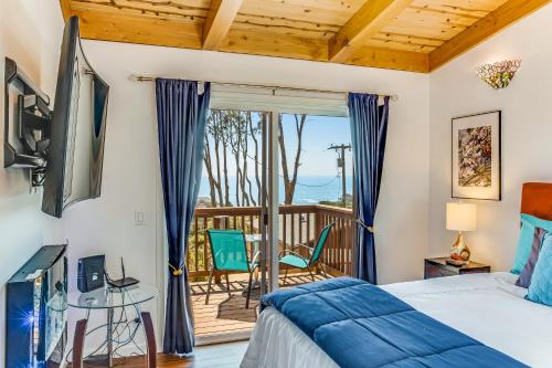 1 dormitorio con 1 cama y balcón en High Tor Upper House with Great Ocean Views, en Gualala
