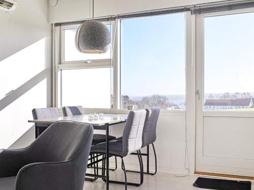 a dining room with a table and chairs and windows at Modern Loft with Sea View - By Traum Ferienwohnungen in Allinge