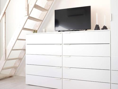 a white dresser with a tv on top at Modern Loft with Sea View - By Traum Ferienwohnungen in Allinge