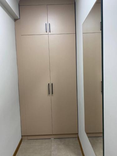 um armário com armários brancos e um espelho em Уютная квартира-студия ЖК Теремки em Almaty