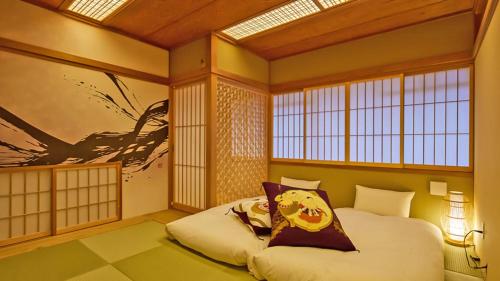 a bedroom with a bed in a room with windows at Stay SAKURA Tokyo Asakusa Yokozuna Hotel in Tokyo