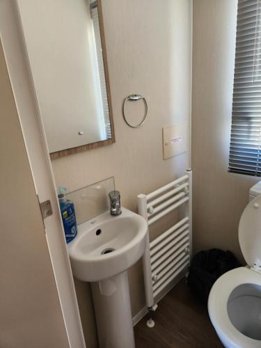 y baño con lavabo y aseo. en 4 BEDROOMS CARAVAN at Waterside Leisure Holiday Park en Skegness