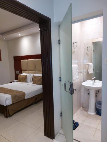 sypialnia z łóżkiem oraz łazienka z umywalką w obiekcie Nawara Apartments 24 w Rijadzie