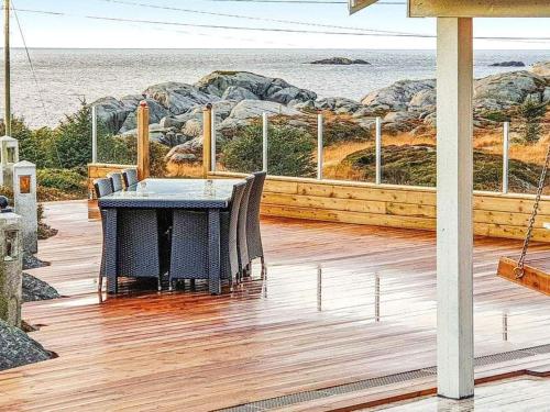 a wooden deck with a table and chairs on the beach at 6 person holiday home in skudeneshavn-By Traum in Skudeneshavn