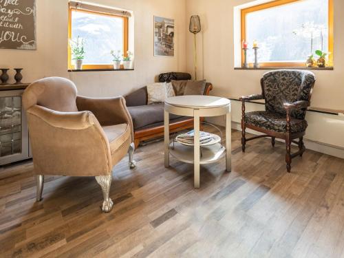 een woonkamer met stoelen, een bank en een tafel bij Chalet in Rangersdorf in Carinthia near ski area in Rangersdorf