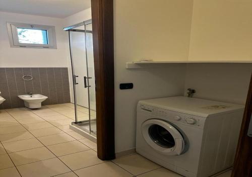 y baño con aseo y lavadora. en Residence La Settima, en Milano Marittima