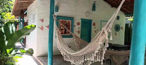 a porch with a hammock on a house at 4eTal Trancoso in Trancoso