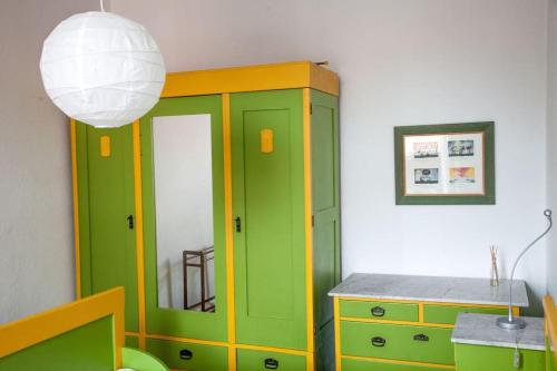 a green cabinet and a table in a room at Idyllische Ferienwohnung auf altem Bauernhof in Emmerthal
