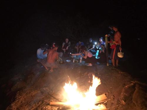 a group of people sitting around a bonfire at night at FamilyHouse & Trekking in Banlung