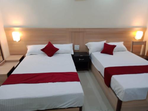 two beds in a hotel room with red pillows at HOTEL STAR HOLIDAY PVT LTD in Bhairāhawā