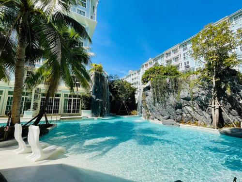 einen Pool in einem Resort mit Palmen in der Unterkunft Grand Florida Beachfront Pattaya H502 in Na Jomtien