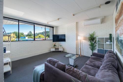 a living room with a couch and a large window at Centre of town - Great views in Monbulk