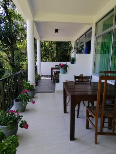 a porch with a wooden table and potted plants at Super View in Ella