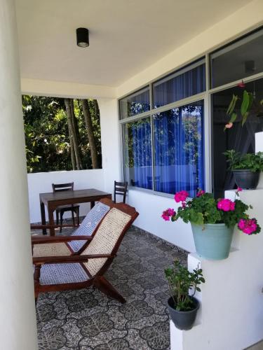 a porch with two chairs and a table and flowers at Super View in Ella
