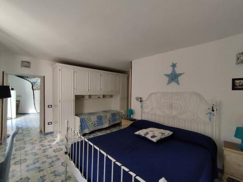 a bedroom with a bed with a blue comforter at La Conchiglia Vietrese in Vietri sul Mare