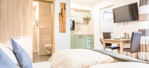 a bedroom with a bed and a desk with a television at Weisses Rössl in Pfreimd