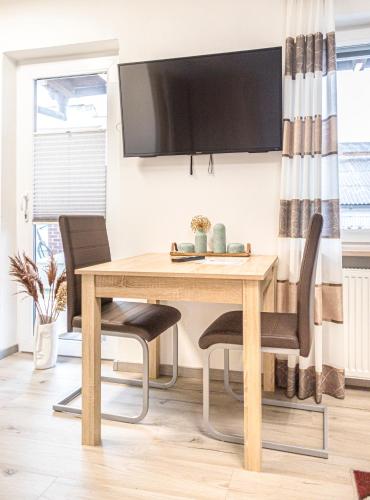 a dining room table with chairs and a tv on the wall at Weisses Rössl in Pfreimd