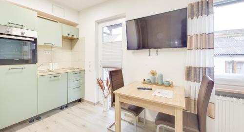 a kitchen with a table and a tv on the wall at Weisses Rössl in Pfreimd