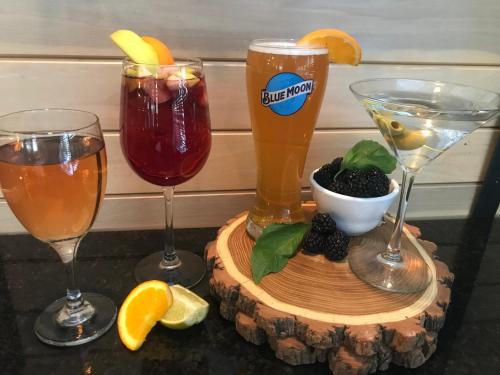 three glasses of drinks on a wooden tray with fruit at Holiday Inn Cleveland-Mayfield by IHG in Mayfield