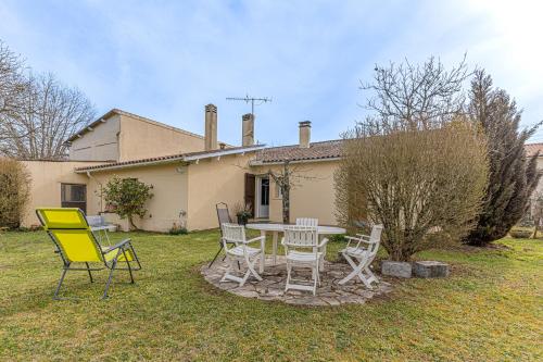 a table and chairs in front of a house at L'Arriga - Maison pour 6 personnes in Gradignan