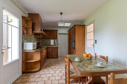 a kitchen with a table and chairs and a kitchen with a window at L'Arriga - Maison pour 6 personnes in Gradignan
