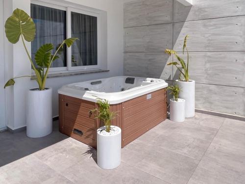 a bath tub with three potted plants in a bathroom at Courtyard Long Beach Holiday Resort in Iskele