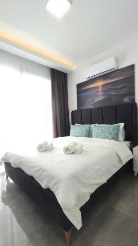 a bedroom with a large bed with two towels on it at Courtyard Long Beach Holiday Resort in Iskele