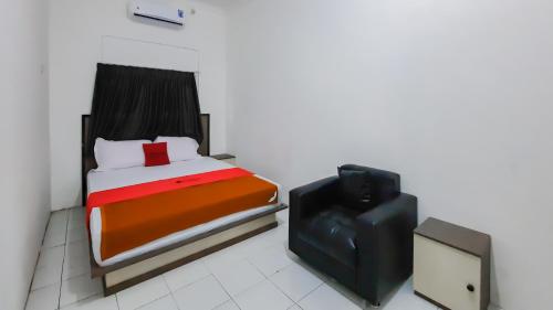 1 dormitorio pequeño con 1 cama y TV en RedDoorz near Universitas Palangkaraya 3, en Palangkaraya