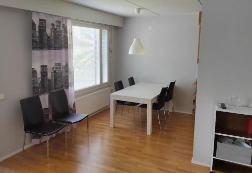 een eetkamer met een witte tafel en stoelen bij Spacious super located Lahti apartment in Lahti