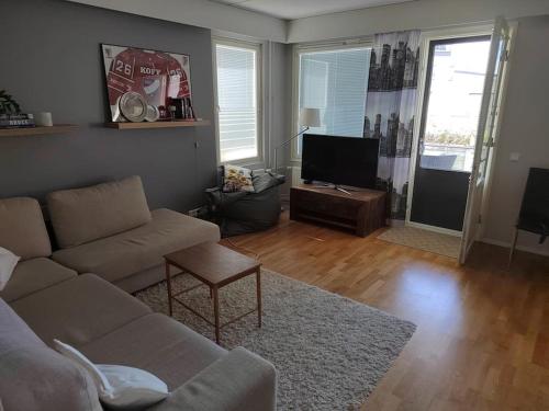 uma sala de estar com um sofá e uma televisão de ecrã plano em Spacious super located Lahti apartment em Lahti