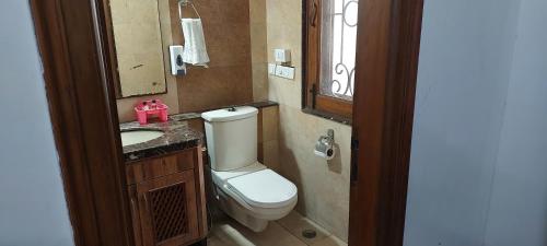 a bathroom with a toilet and a sink and a mirror at Hotel Ashray Noida in Noida