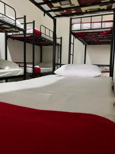 a bedroom with three bunk beds with white sheets at Yayah Hostel in Bogor