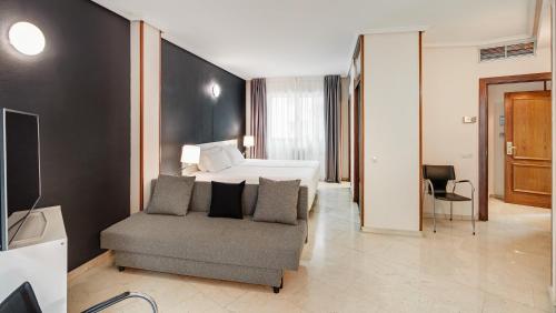 una camera d'albergo con letto e sedia di Sercotel Togumar a Madrid