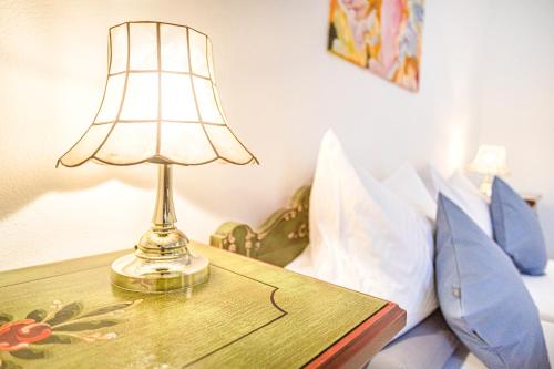 a lamp on a table next to a bed at Weisses Rössl in Pfreimd