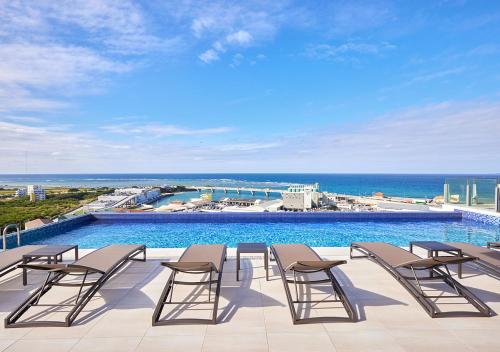 a group of chairs and a swimming pool at HOTEL AlaCOOJU OKINAWA in Urasoe