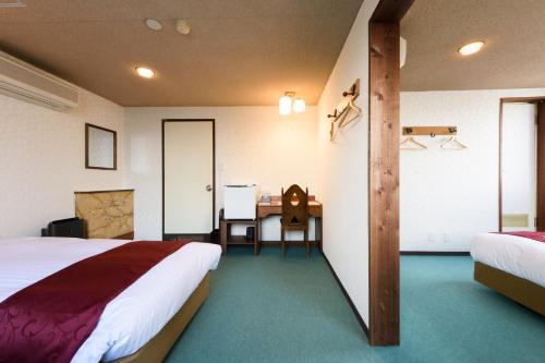 a hotel room with a bed and a desk at Hotel New Moustache in Shizuoka