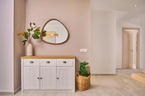 a bathroom with a white cabinet and a mirror at Sea Front Zante Apartments in Zakynthos Town