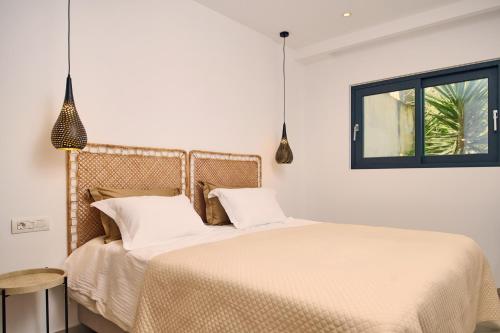 a bedroom with a bed with white sheets and a window at Sea Front Zante Apartments in Zakynthos Town