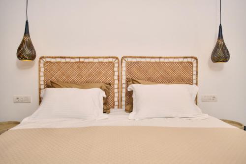 a bedroom with a bed with white sheets and pillows at Sea Front Zante Apartments in Zakynthos Town