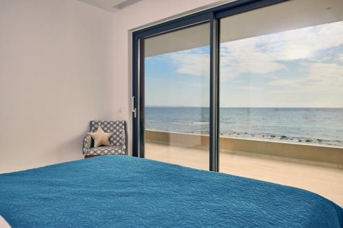 a bedroom with a bed and a view of the ocean at Sea Front Zante Apartments in Zakynthos Town