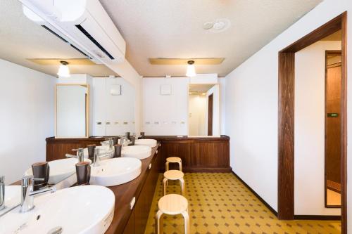 uma casa de banho com quatro lavatórios e uma fila de espelhos em Hotel New Moustache em Shizuoka