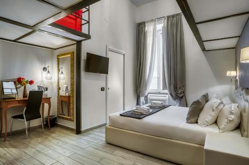 Habitación de hotel con cama, escritorio y escritorio. en Operà Suites Pinciana, en Roma