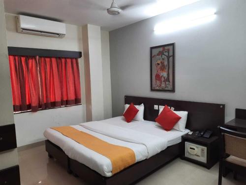 ein Schlafzimmer mit einem großen Bett mit roten Kissen in der Unterkunft SPOT ON Hotel The Annie in Bilāspur