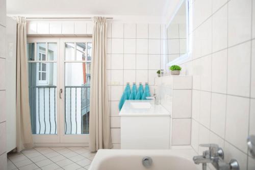 La salle de bains blanche est pourvue d'une baignoire et d'un lavabo. dans l'établissement Haus mit 110qm und Garten 150m zum Wasser, à Stralsund