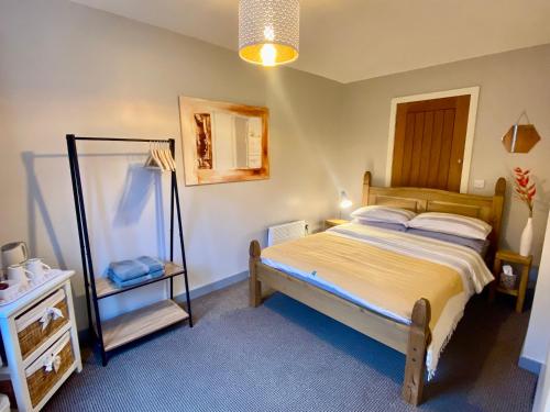 a small bedroom with a bed and a mirror at Inversnaid Bunkhouse in Inversnaid