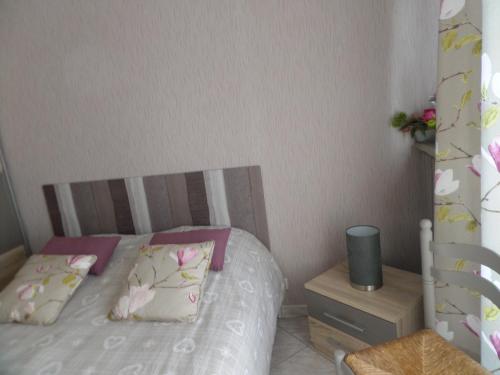 a small bedroom with a bed and a night stand at Les Puits Bessin Normandie in Sommervieu